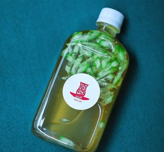 بطری نوشیدنی خنک و طبیعی کافه روحی (محوطه باغ نگارستان) با برش‌های لیمو یا خیار تازه، طعمی دلچسب و گوارا.