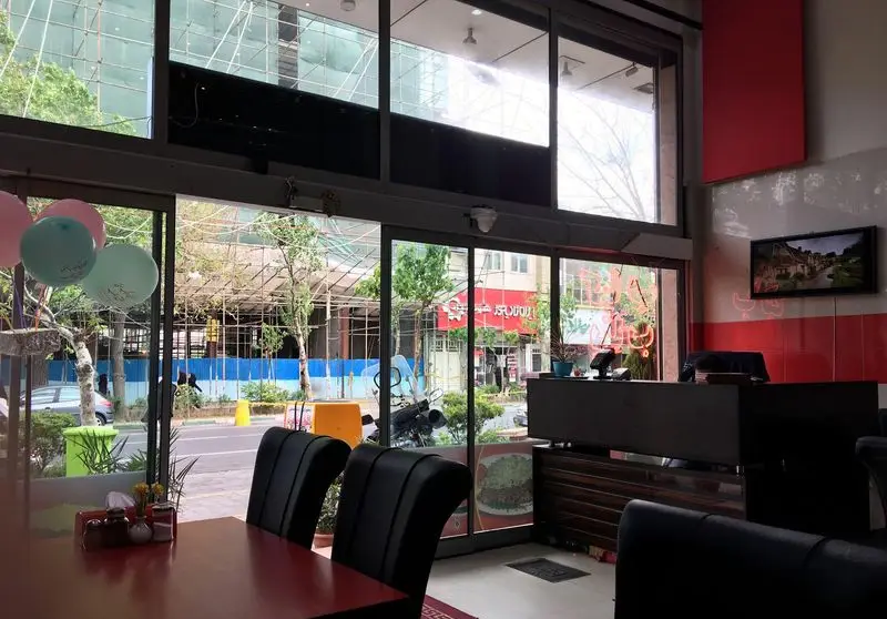 تصویر داخلی رستوران و کباب سنتی افق بناب: فضایی مدرن و سنتی با میز و صندلی‌های راحت، بادکنک‌های شاد و چشم‌اندازی زیبا به شهر.