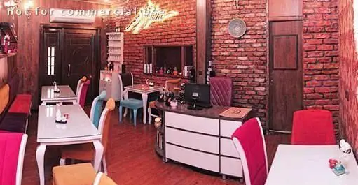 فضای داخلی رستوران کلاسیک با طراحی دیوارهای آجری قرمز و میز و صندلی‌های مدرن. محیطی دلنشین و دنج برای تجربه یک غذای به یادماندنی.