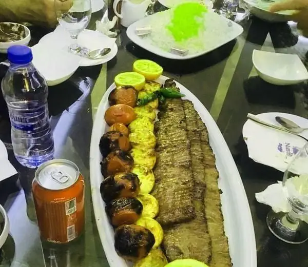 میز غذای پر از کباب های لذیذ ایرانی (کوبیده و جوجه) در رستوران نوید، همراه با برنج و مخلفات تازه برای تجربه ای به یادماندنی.