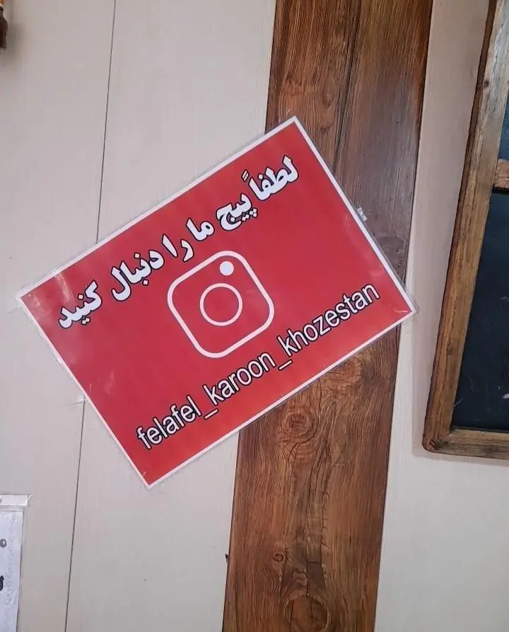 تابلو قرمز فست فود فلافل کارون خوزستان با لوگوی اینستاگرام، آیدی felafel_karoon_khozestan، برای اطلاع از منو و تخفیف‌ها.