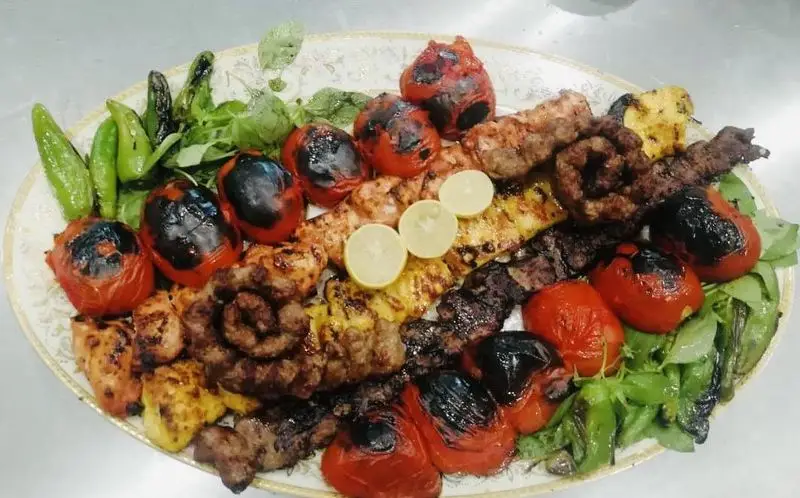 بشقاب بزرگ کباب کوبیده، جوجه کباب و کباب برگ با گوجه کبابی و فلفل سبز تازه، آماده سرو در خانه کباب درین.