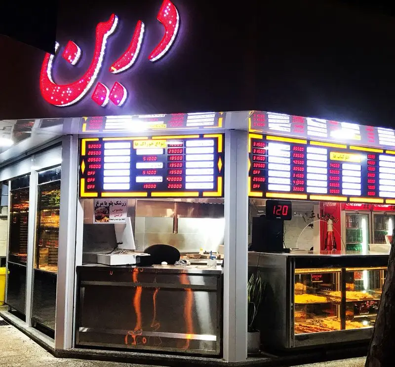 خانه کباب درین: نمای شب رستوران درین با تابلوی نورانی، منوی انواع کباب، جوجه، زرشک پلو با مرغ و قیمت‌ها.