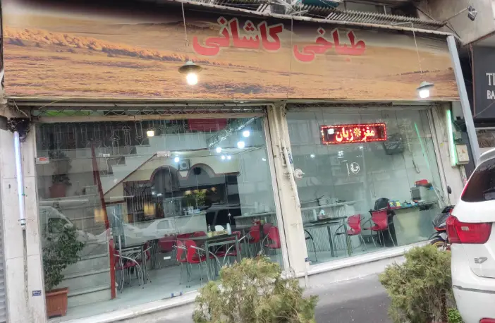 تصویری از نمای بیرونی و تابلو طباخی کاشانی، رستوران سنتی ایرانی متخصص در طبخ لذیذ کله پاچه، مغز و زبان برای مشتریان.