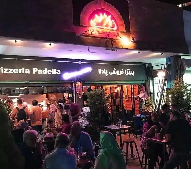 پیتزا فروشی پادلا با فضای باز دلنشین در شب، میزبان مشتریان برای سرو پیتزاهای لذیذ و تجربه ای به یادماندنی از فست فود.