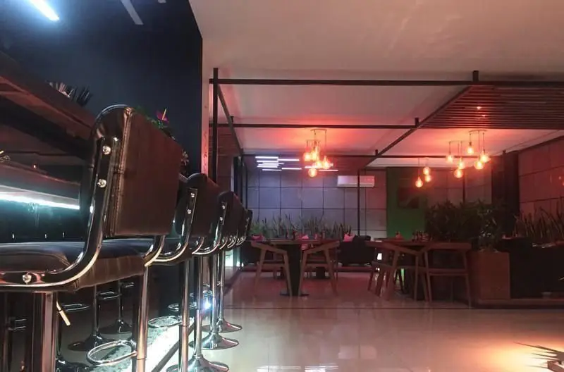 دکوراسیون شیک و مدرن کافه رستوران ماینس وان، شامل میز و صندلی‌های غذاخوری، بار با صندلی‌های بلند و نورپردازی محیطی جذاب و آرامش‌بخش.