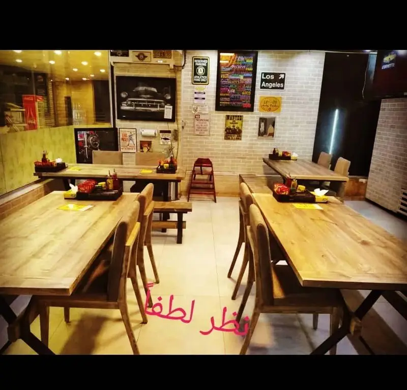 فضای داخلی شیک و دنج رستوران پیتزا آرد با میز و صندلی‌های چوبی، دکوراسیون وینتیج و دیوار آجری، محیطی دلنشین برای صرف غذا.