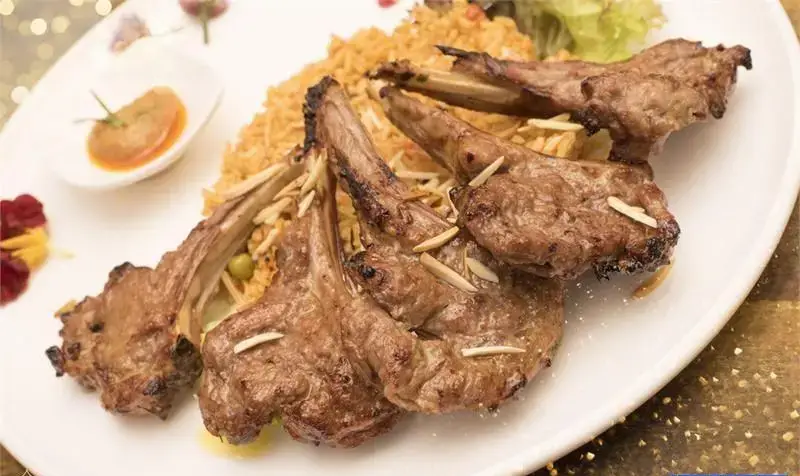 دنده کباب بره لذیذ رستوران مراکش الجزایر با پلو زعفرانی و خلال بادام، تجربه‌ای اصیل از غذای مراکشی و الجزایری.
