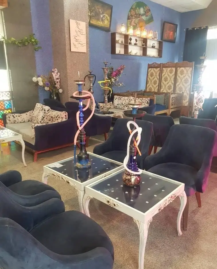 کافه عربی ویانا، فضایی گرم و دلپذیر با دکوراسیون سنتی-مدرن، مبلمان راحتی آبی مخملی و قلیان‌های شیک برای تجربه‌ای خاص و آرام.