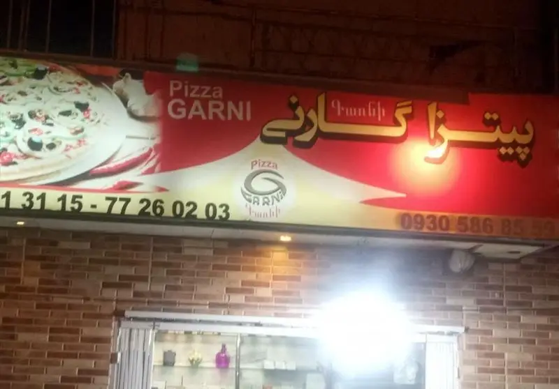 تابلوی پیتزا گارنی (Pizza GARNI) به زبان فارسی، انگلیسی و ارمنی (Գառնի) با عکس پیتزا و شماره تلفن‌ها.