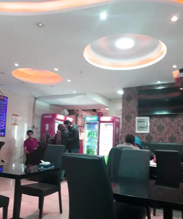 فضای داخلی روشن و مدرن کبابی کباب عموحسن با دکوراسیون شیک، میز و صندلی راحت برای مشتریان و یخچال نوشیدنی.