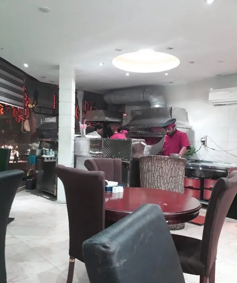 نمایی از محیط داخلی کبابی کباب عموحسن با آشپزان ماهر در حال تهیه انواع کباب و نان داغ، فضایی گرم و دلنشین برای صرف غذا.