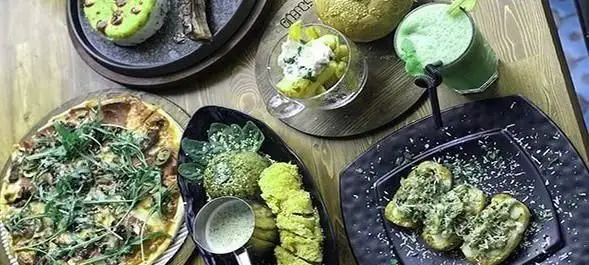 تصویری از میز غذای رنگارنگ در رستوران ایتالیایی ویتندی: پیتزا، پیش‌غذا، نوشیدنی سبز و دسرهای اشتهاآور. طعم اصیل ایتالیایی.