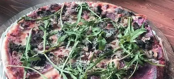 پیتزا رستوران ایتالیایی ویتندی با لایه‌های رنگارنگ و سبزیجات تازه آرگولا. طعمی بی‌نظیر برای علاقمندان به غذای ایتالیایی.