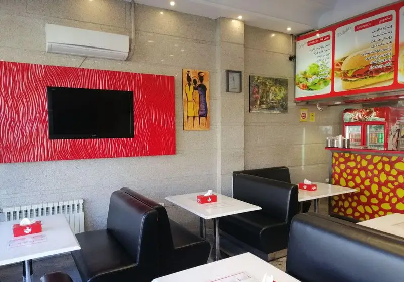 محیط داخلی فست فود پیتزا دلفین با دکوراسیون مدرن، منوی متنوع ساندویچ و سالاد، میز و صندلی‌های شیک برای تجربه‌ای دلنشین.