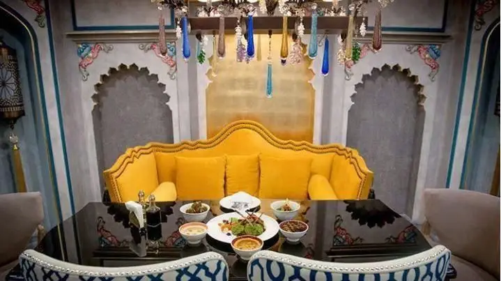 تصویری از فضای دلنشین و دکوراسیون سنتی و لوکس رستوران عربی خیمه با مبل راحتی زرد، میز چیده‌شده با غذاهای خوشمزه و طراحی اصیل.