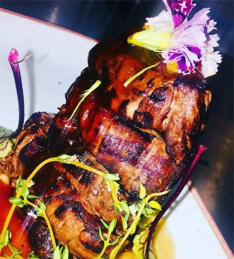 غذای لذیذ و مجلل در رستوران عربی خیمه: خوراک گوشت گریل شده با سس خاص، تزئین شده با سبزیجات معطر و گل خوراکی. تجربه ای فراموش نشدنی!