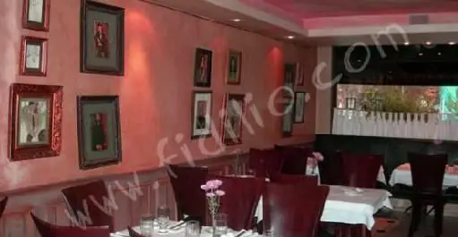 فضای داخلی شیک و دنج رستوران آنترو کوت با دیوارهای صورتی، قاب عکس‌های زیبا، میز و صندلی‌های راحت و چیدمان لوکس.