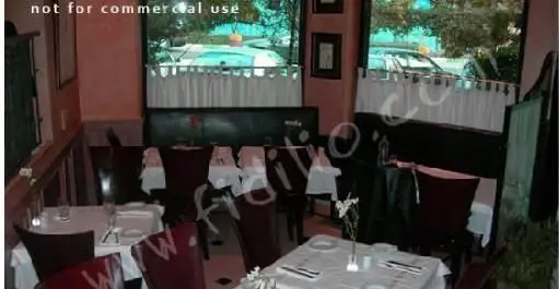 فضای داخلی شیک رستوران آنترو کوت با میزهای چیدمان شده، صندلی‌های راحت و پنجره‌ای رو به خیابان برای تجربه‌ای دلنشین.