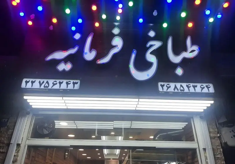 تابلو ورودی طباخی فرمانیه در تهران، با نورپردازی چشم‌نواز و شماره تلفن‌های ۲۲۷۵۶۴۴۳ و ۲۶۸۵۴۳۹۶. بهترین کله پاچه در منطقه فرمانیه.