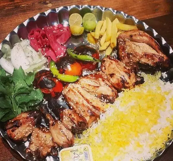 سینی کباب میکس ایرانی شامل جوجه کباب، برنج زعفرانی، گوجه و فلفل کبابی، سیب زمینی و سبزی تازه از سفره خانه دیلمان.