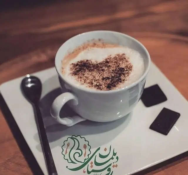 قهوه کاپوچینو با طرح قلب روی فوم، همراه با شکلات تلخ، تجربه ای دلپذیر در سفره خانه و کافه روستای دیلمان.
