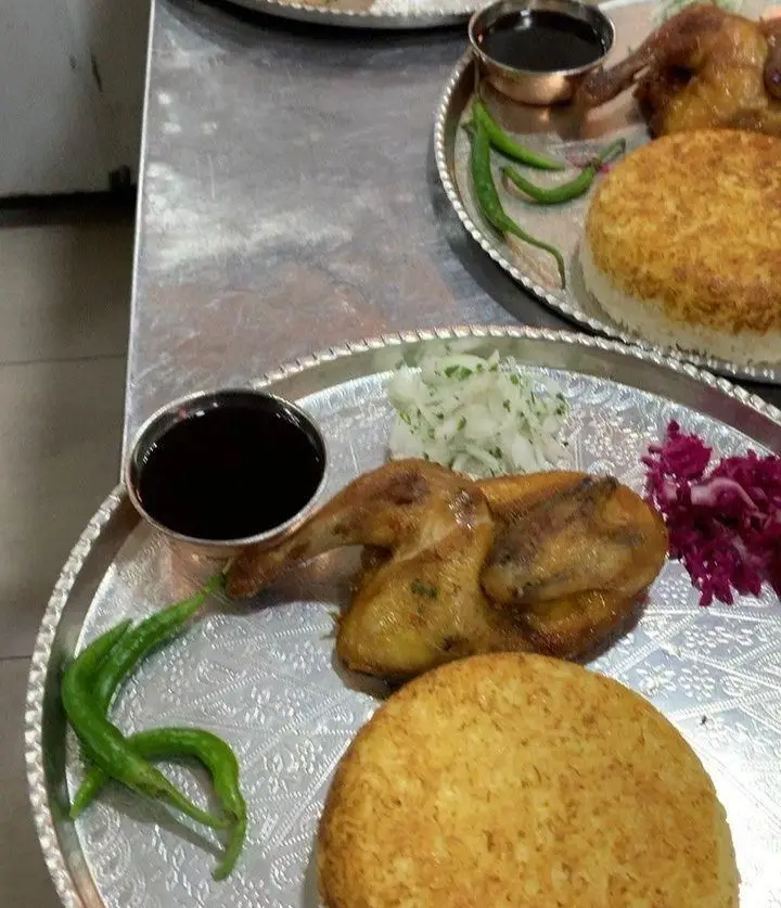 تصویری جذاب از جوجه برشته و ته دیگ طلایی در رستوران هانی مطهری، همراه با سس و مخلفات تازه برای تجربه‌ای بی‌نظیر.