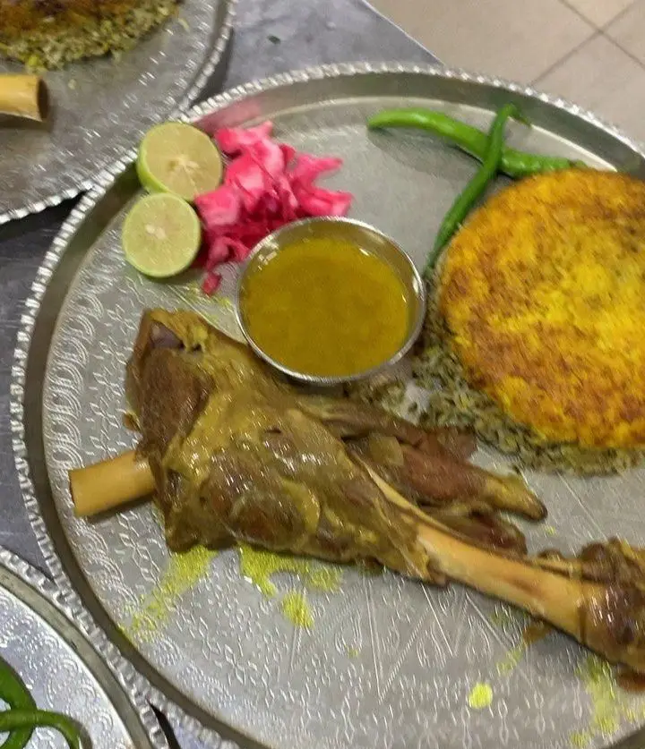 ماهیچه گوسفندی لذیذ با ته‌دیگ زعفرانی و برنج سبزی در رستوران هانی مطهری، یک غذای اصیل و سنتی ایرانی برای تجربه طعم بی‌نظیر.