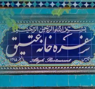 تابلو کاشیکاری آبی رستوران سنتی عقیق بابا قدرت، با نوشته سفرهخانه عقیق و کالیگرافی زیبا. غذای اصیل ایرانی.