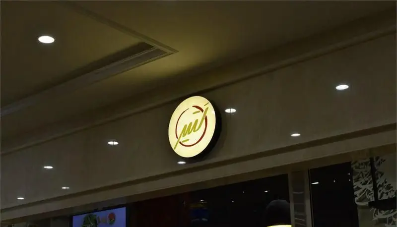 نمایی از تابلوی روشن و دایره‌ای رستوران ایرانی لتیر، با لوگوی خاص و برجسته بر سردر ورودی، جهت جذب مشتریان.