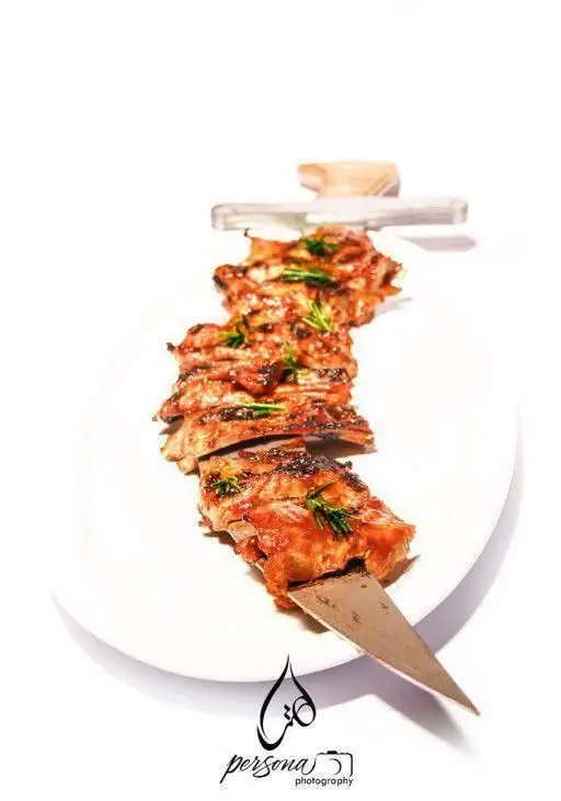 تصویری زیبا از دنده کباب گریل شده و آبدار سرو شده در کافه رستوران هترا، انتخابی ایده‌آل برای یک وعده غذایی لذیذ و به یادماندنی در محیطی دلنشین.