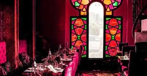 فضای داخلی چشم‌نواز کافه رستوران هترا با پنجره‌های رنگی و دکوراسیون سنتی، مکانی آرام برای میزبانی دلنشین.