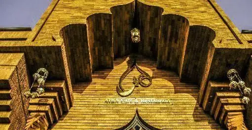 تصویری از نمای خارجی و ورودی جذاب کافه رستوران هترا با دکوراسیون آجری خیره‌کننده و نشان ویژه، آماده پذیرایی از میهمانان.