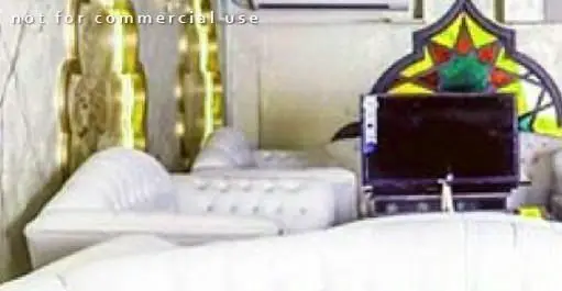 تصویری از فضای داخلی دلنشین کافه رستوران هترا با مبلمان راحتی سفید، تلویزیون و دکوراسیون شیک و مدرن برای مشتریان.