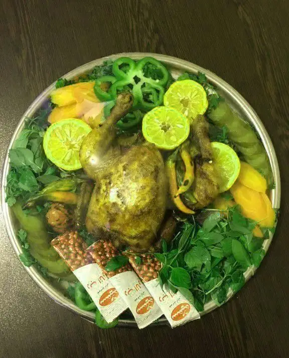 سینی بزرگ تهیه غذای امام رضا شامل دو مرغ بریان مجلسی با مخلفات لیمو، فلفل دلمه‌ای، سبزی تازه و بادام زمینی. مناسب مهمانی‌ها.