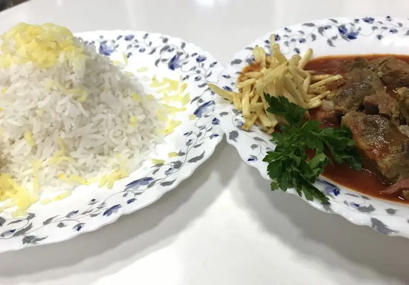 غذای اصیل ایرانی از رستوران مددی شامل پلو زعفرانی و خورشت گوشت با سیب زمینی سرخ کرده و جعفری تازه. بهترین انتخاب برای ناهار و شام.