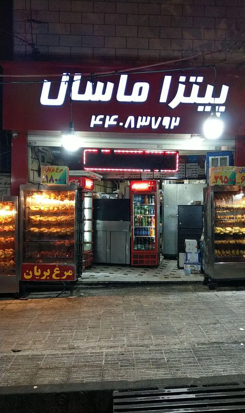 نمای شبانه پیتزا ماسال با تابلو روشن، نمایش مرغ بریان تازه و شماره تماس جهت سفارش پیتزا، ساندویچ و مرغ بریان.
