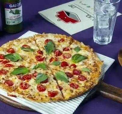 پیتزا مارگاریتا با گوجه گیلاسی و برگ ریحان تازه در کافه رستوران آهون، انتخابی دلنشین برای یک وعده غذای خوشمزه و سالم.