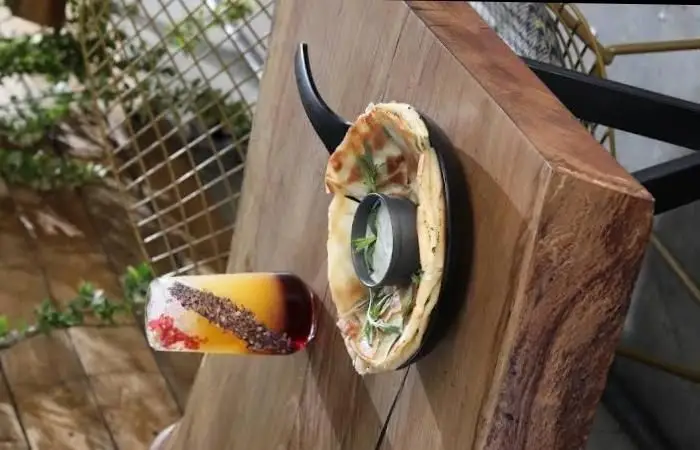 نمایی زیبا از غذای خوشمزه و نوشیدنی خاص در بالکافه، با دکوراسیون شیک و میز چوبی. تجربه طعمی دلپذیر در کافه بالکافه.