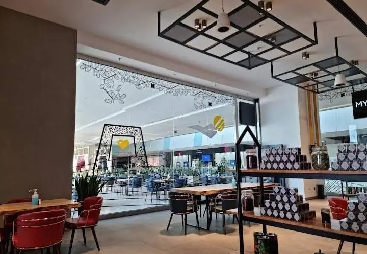 دکوراسیون داخلی کافه بالکافه، محیطی دلپذیر و مدرن برای نوشیدنی و استراحت، با محصولات متنوع چای و قهوه آماده فروش.