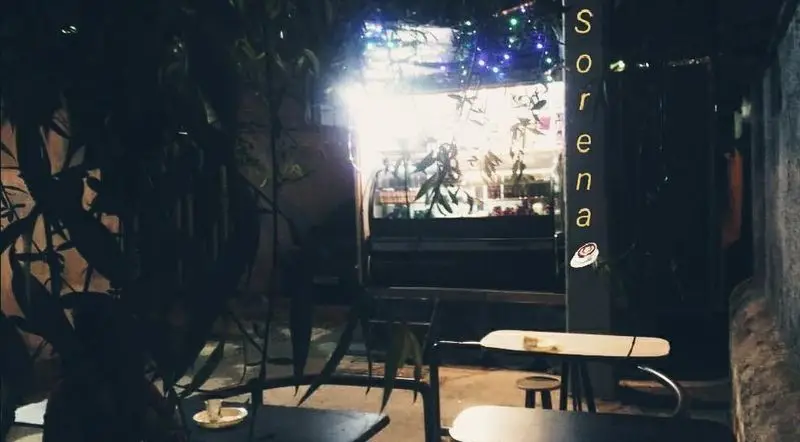 نمایی شبانه و دلنشین از کافه فست فود سورنا (سیار) با فضای باز، میز و صندلی‌های چوبی، و نورپردازی زیبا برای تجربه غذایی لذت‌بخش.