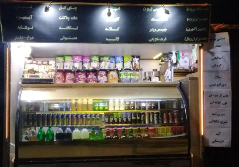 کافه فست فود سیار سورنا با منوی متنوع نوشیدنی‌های گرم و سرد، ساندویچ، برگر، چیپس و انواع خوراکی در یک شب تاریک.