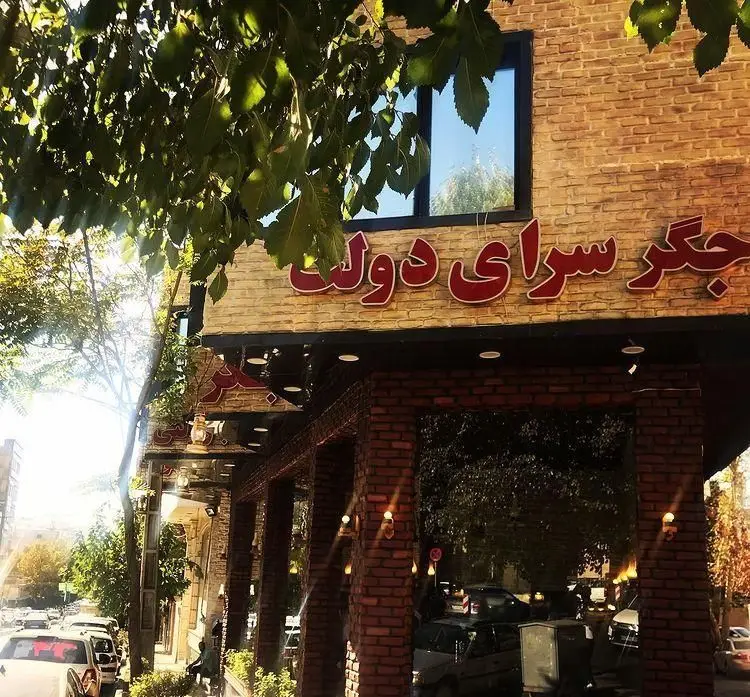 نمای جذاب و دلنشین جگرسرای دولت، رستوران معروف جگرکی با طراحی آجری، تابلوی روشن و فضای سبز شهری در تهران.