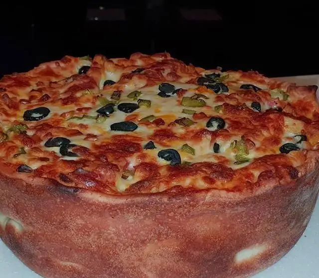 پیتزا دیپ دیش مخصوص رستوران آروما با پنیر فراوان، زیتون سیاه و فلفل سبز، ظاهری اشتهاآور و طعمی بی نظیر.