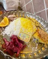 غذای خوشمزه ایرانی کافه قلیان پیر بابا شامل چلوپلو، خورشت و مخلفات در بشقاب سنتی. بهترین تجربه غذایی و قلیان در یک مکان.