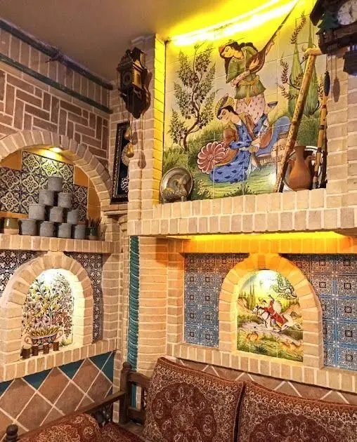 فضای داخلی و دکوراسیون سنتی کافه قلیان پیر بابا، شامل آجرکاری، کاشی‌کاری‌های دستی و نقاشی‌های اصیل ایرانی.
