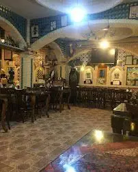 تصویری از فضای داخلی سنتی و دنج کافه قلیان پیر بابا، با دکوراسیون گرم، میز و صندلی‌های راحت، انتخابی ایده‌آل برای یک دورهمی خاص.