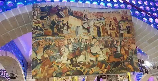 نقاشی دیواری بزرگ و تاریخی کافه قلیان پیر بابا با صحنه‌های مبارزات باستانی، اسب‌سواران و شخصیت‌های سنتی ایرانی.