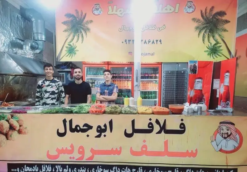 فلافل فروشی سلف سرویس ابوجمال با کارکنان جوان، پیشخوان رنگارنگ مواد تازه و آماده برای سرو یک وعده غذایی لذیذ.