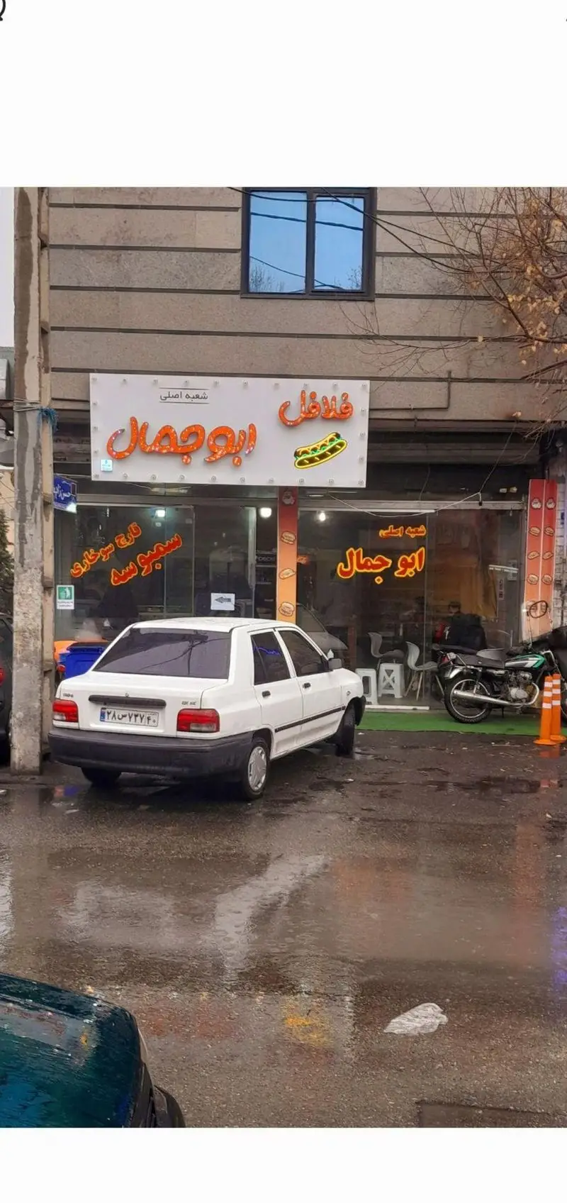 تصویر فلافل فروشی ابوجمال شعبه اصلی، مکانی برای تجربه طعم لذیذ ساندویچ و غذاهای محبوب، با یک خودرو در نمای جلو.